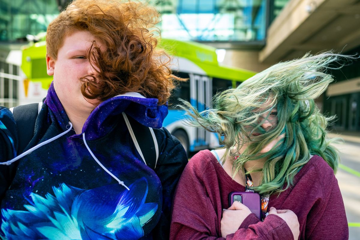 Terri Patten, left, and Aaralynn Gilbert, both 16, wait in a wind vortex for their bus to arrive at the STA Plaza on Monday in Spokane.  (COLIN MULVANY/THE SPOKESMAN-REVIEW)