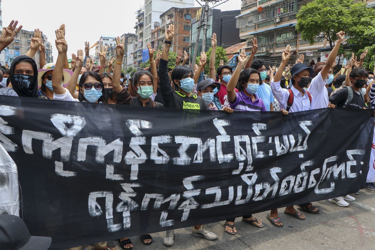 Anti-coup protesters flash the three-finger salute, holding banner read " Yangon Strike will defeat all enemies" during a demonstration against the military coup in Yangon, Myanmar, on Monday, April 26, 2021. Southeast Asian leaders have demanded an immediate end to killings and the release of political detainees in Myanmar during an emergency summit in Jakarta with its top general and coup leader.  (STR)