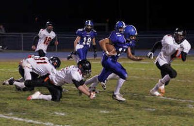 
Coeur d'Alene quarterback J.J. Turbin breaks free from Post Falls defenders in the first quarter. Special to 
 (Bruce Twitchell Special to / The Spokesman-Review)