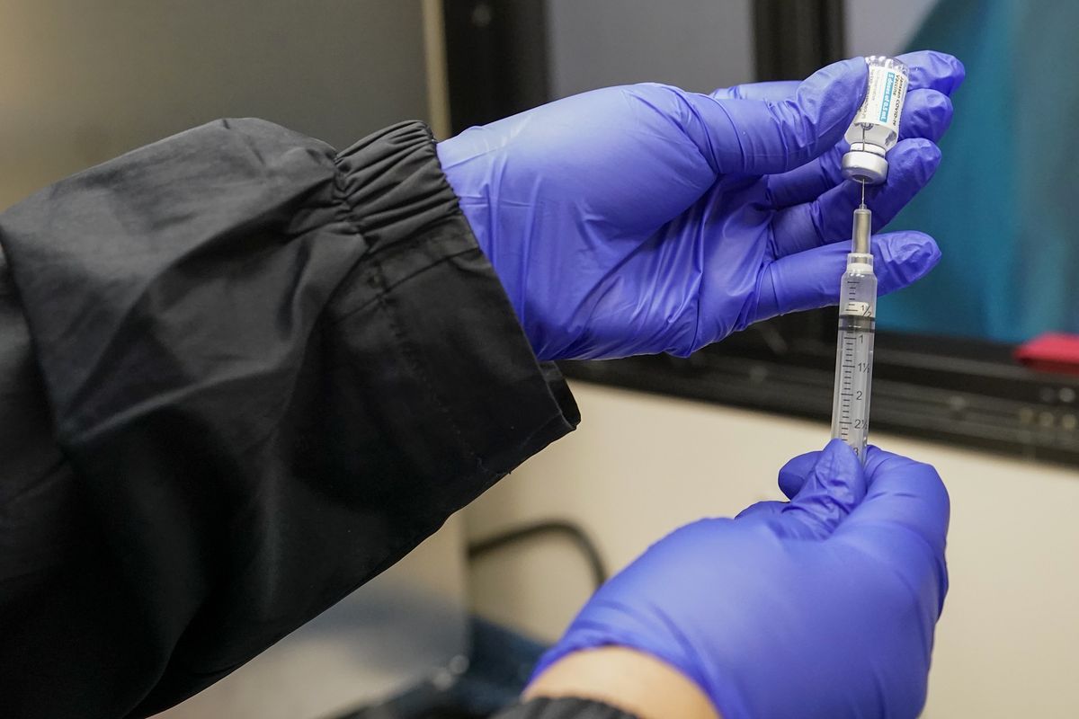 A nurse fills a syringe with a dose of the Johnson & Johnson