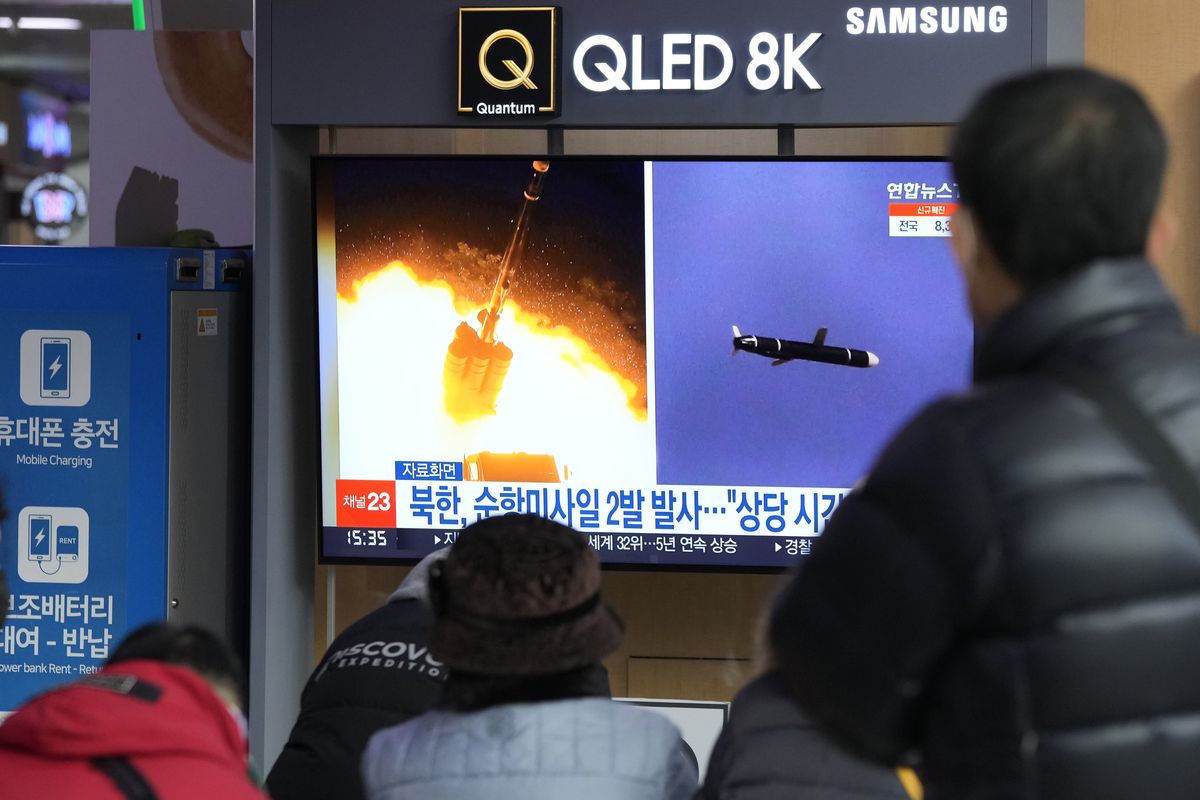 People watch a TV showing file images of North Korea