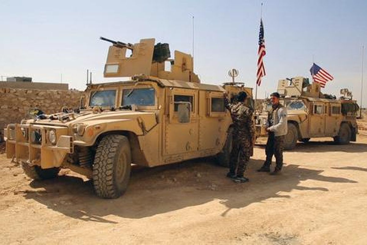 This March 7, 2017, file frame grab from video provided by Arab 24 network, shows fighters from the Syrian Democratic forces standing near U.S military vehicles on the outskirts of the Syrian town of Manbij, in Aleppo province, Syria. (Uncredited / Associated Press)