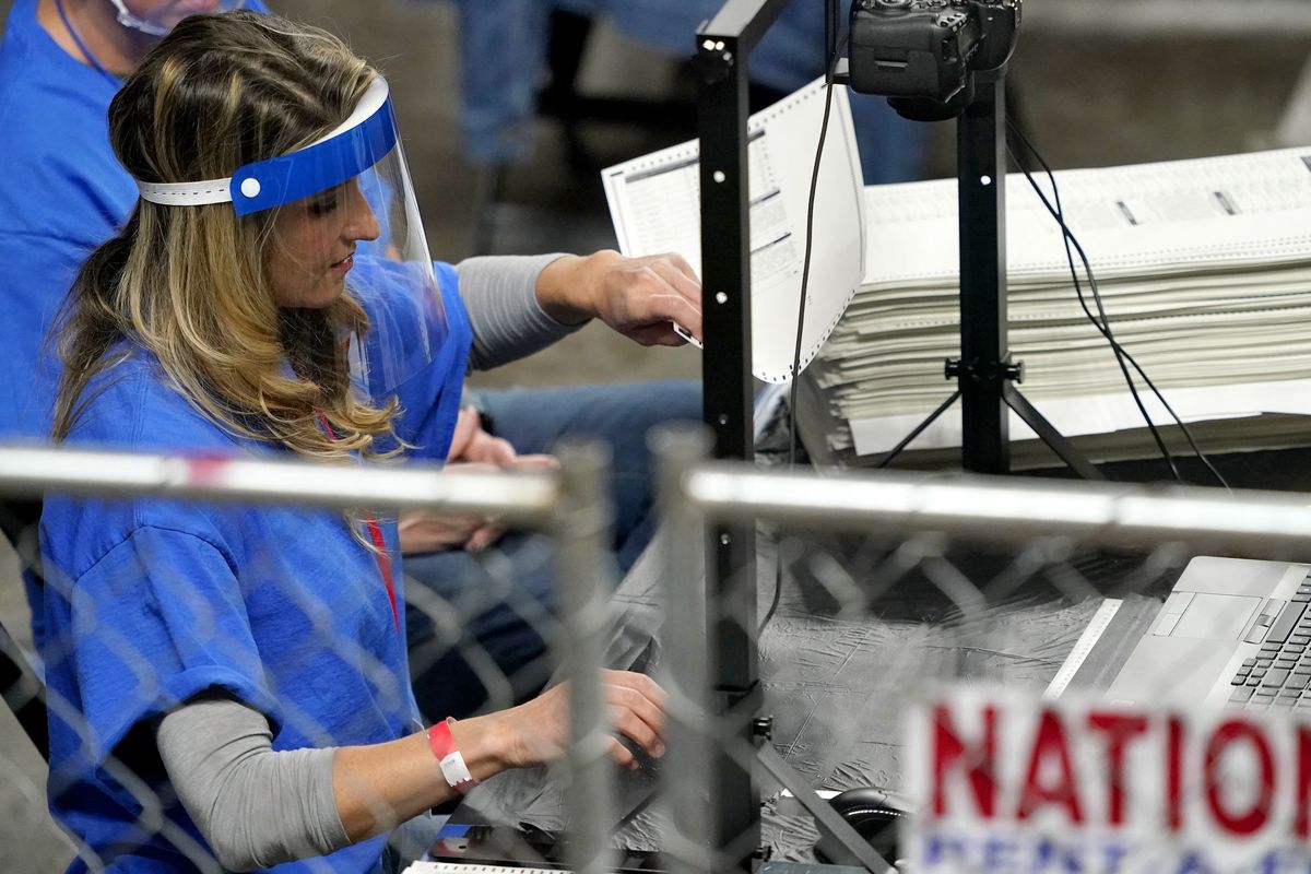 In this May 6, 2021 photo, Maricopa County ballots cast in the 2020 general election are examined and recounted by contractors working for Florida-based company, Cyber Ninjas, at Veterans Memorial Coliseum in Phoenix. Supporters of former President Donald Trump who were hired to review the 2020 vote count in Arizona's largest county are preparing to deliver their report to state Republicans on Monday, though their findings won't immediately be made public.  (Matt York)