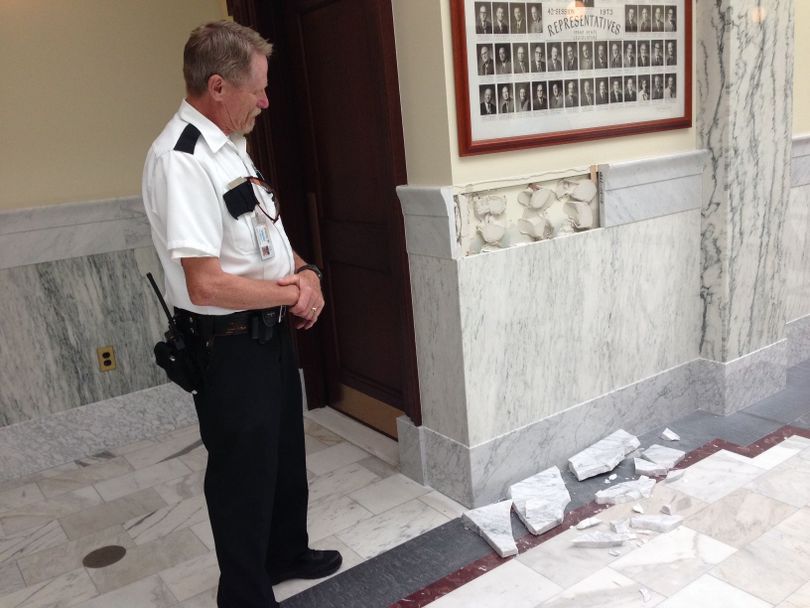 Idaho House Assistant Sergeant-at-Arms Stu Stewart examines marble wainscoting trim that fell and smashed Wednesday at the touch of a 5-year-old girl. (Betsy Z. Russell)