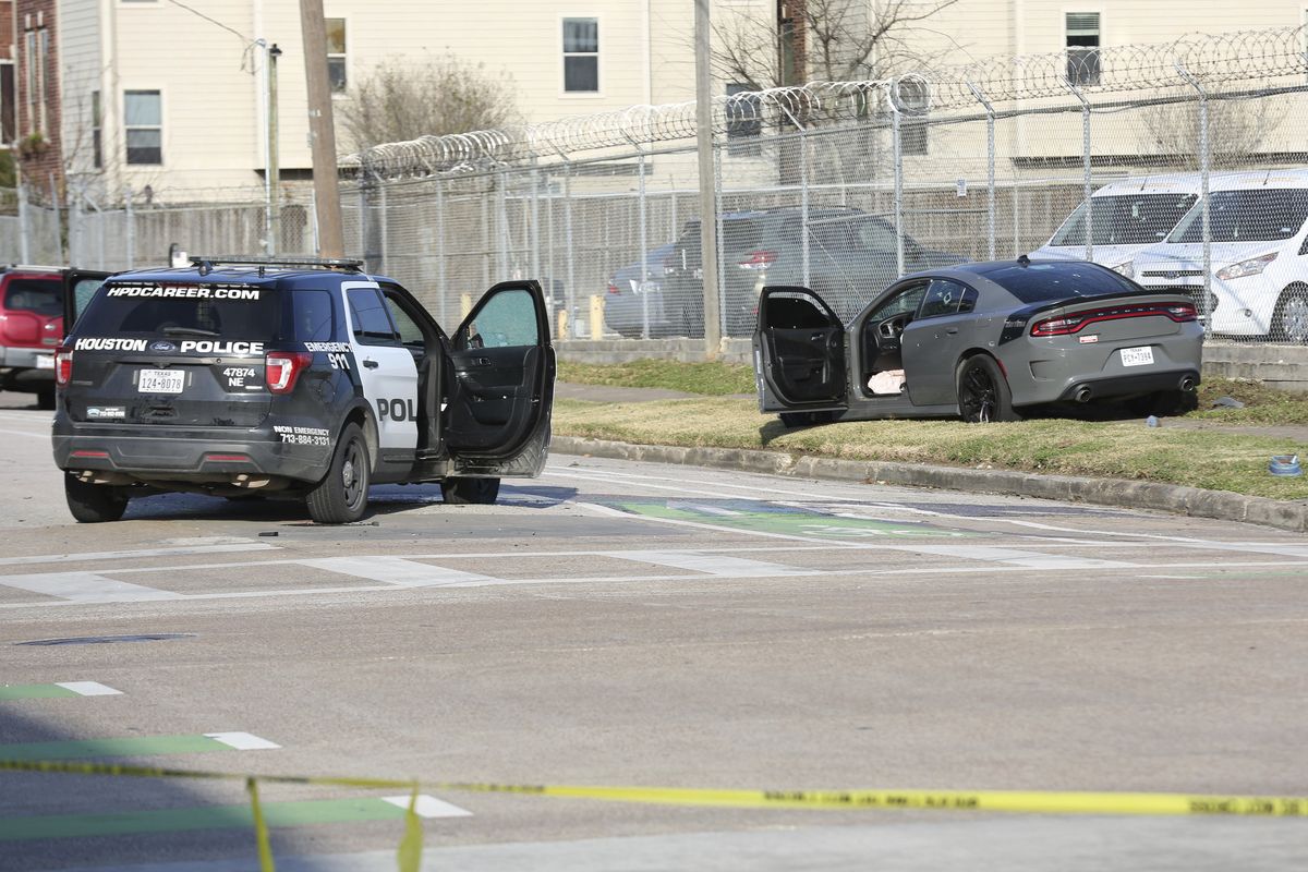 Authorities investigate the scene of a shooting Thursday, Jan. 27, 2022, in Houston. Authorities say a police chase in Houston ended with a shootout that wounded three officers. The incident happened about 2:40 p.m. Thursday when a car that police were pursuing crashed at an intersection just off Interstate 69 on the southeastern edge of downtown Houston.  (Jon Shapley)