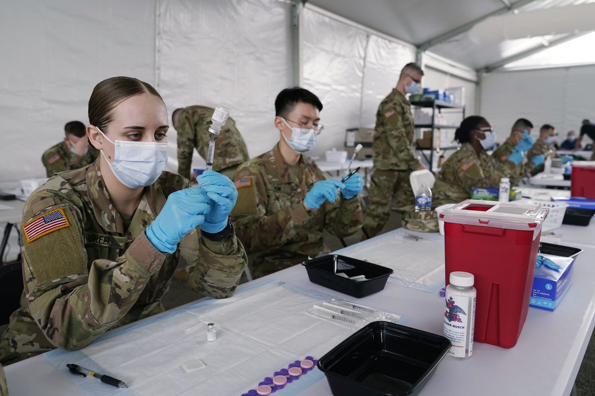 FILE - In this March 9, 2021, file photo, Army health specialists fill syringes with the Pfizer COVID-19 vaccine in Miami. Despite the clamor to speed up the U.S. vaccination drive against COVID-19, the first three months of the rollout suggest faster is not necessarily better.  (Marta Lavandier)