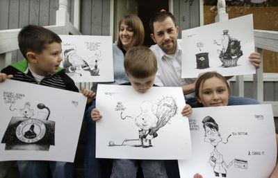 Eric Devericks, top right, recently laid-off from his job as an editorial cartoonist at the Seattle Times, shows off some of his artwork with his wife Brandi and children Sullivan, 5, left, Finnigan, 2, and Amara, 8, in Kenmore, Wash.  (Associated Press / The Spokesman-Review)