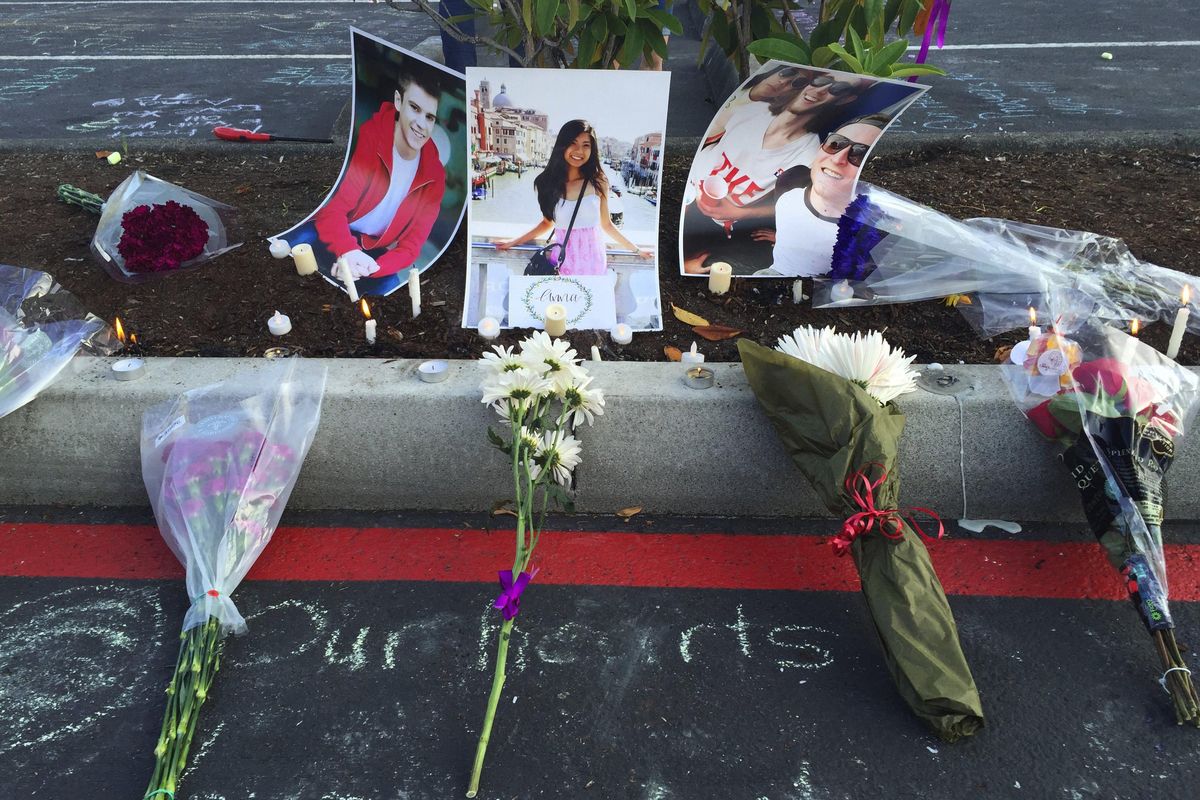 Photos of Jordan Ebner, Anna Bui and Jake Long are seen at a makeshift memorial as people gather in the parking lot of Kamiak High School in Mukilteo, Wash., to honor those who were slain Saturday, July 30, 2016. (Alan Berner / Seattle Times via Associated Press)