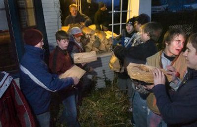 
Members of the Reardan High School football team stack donated firewood outside the home of Gail McClung in Reardan Wednesday. 
 (Holly Pickett / The Spokesman-Review)
