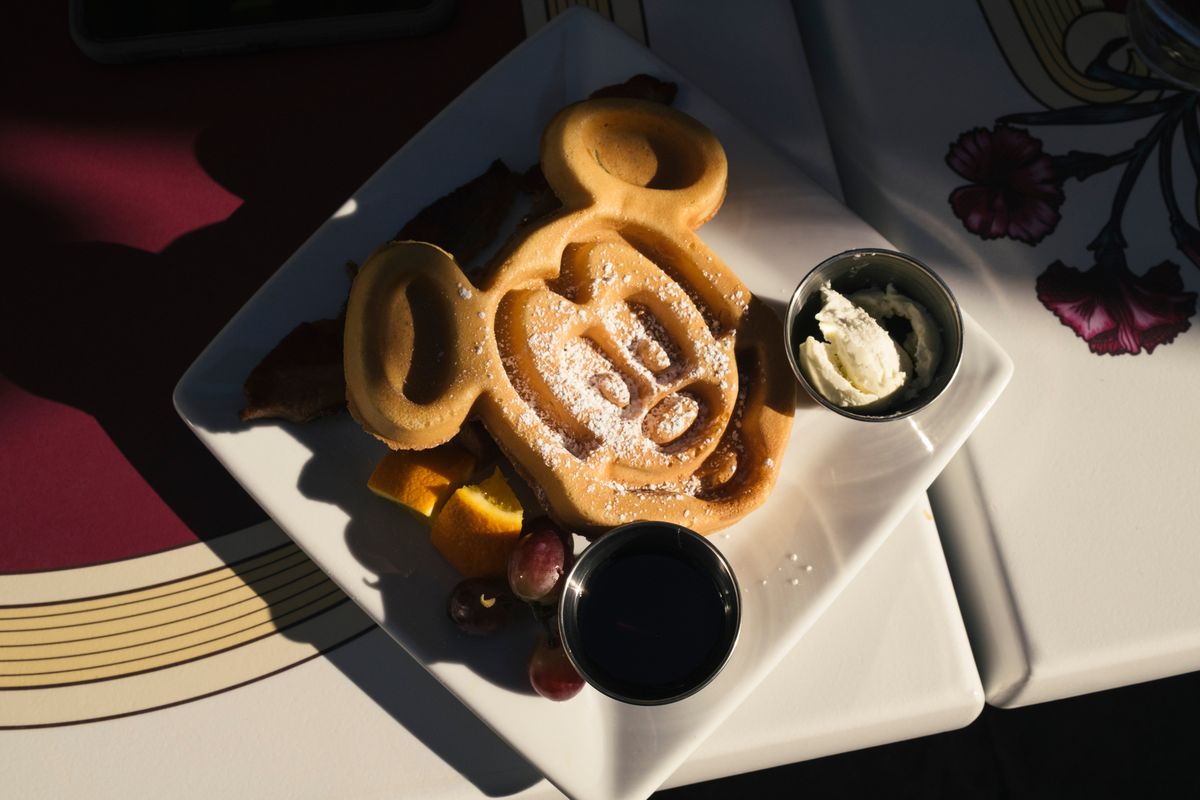 The Mickey-shaped waffle, served with applewood-smoked bacon or smoked sausage at Carnation Cafe at Disneyland in Anaheim, Calif., April 1, 2023. A fascination with the theme parks’ cuisine has spawned fan websites and snagged a New York Times critic, who has a Disney back story of her own.  (GABRIELLA ANGOTTI-JONES/New York Times)