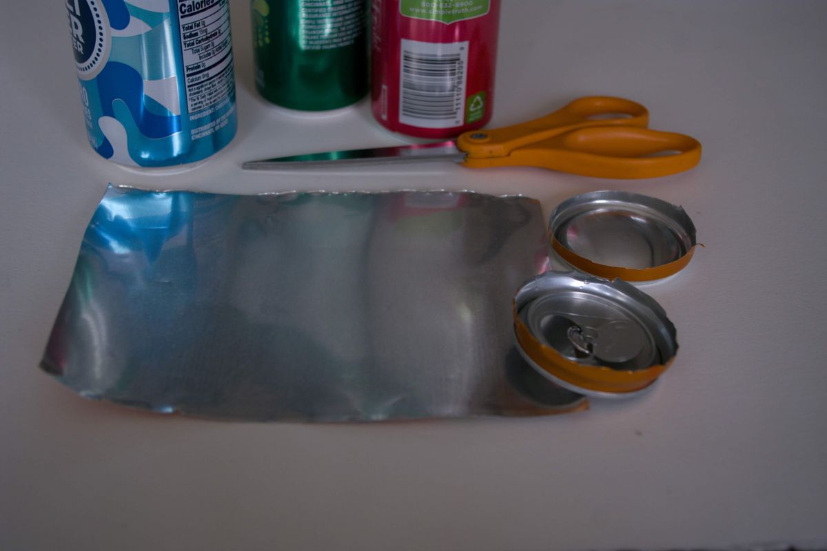 Cut open a clean and empty aluminum can by removing the top and bottom with scissors so that you have a flat rectangular piece to work with here. (Katie Patterson Larson/For The Spokesman-Review)