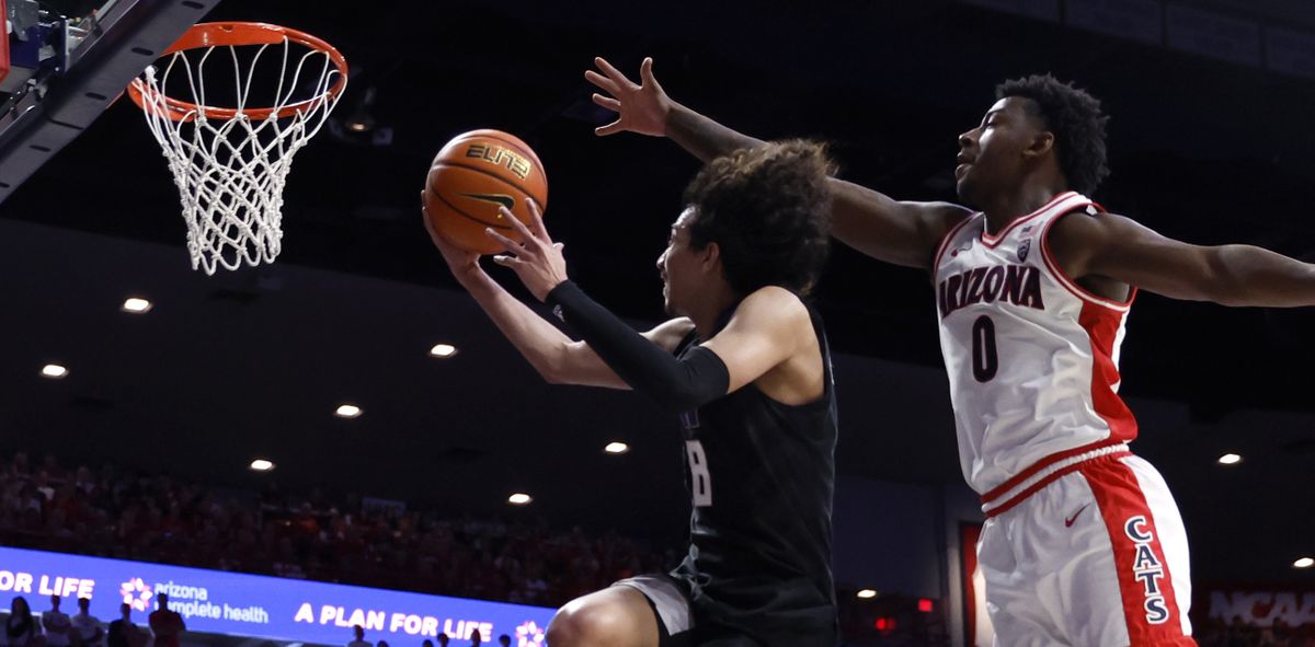 Nate Calmese attempts a driving layup against Arizona’s Jaden Bradley during Washington’s game in Tucson on Feb. 24.  (Getty Images)