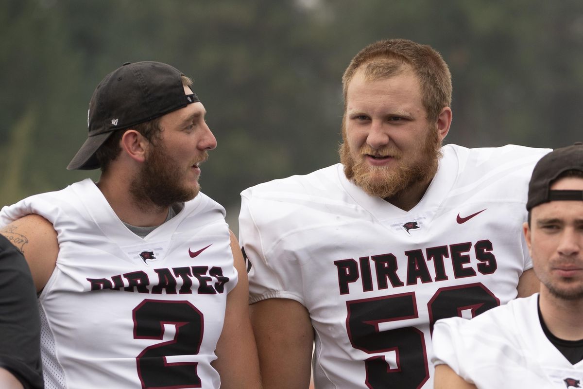 Chad Wilburg (2) and Tyler Adamson (50) of the Whitworth Pirates talk as the team gathers for a meeting  Aug. 25 after a  scrimmage at the Pine Bowl. (Jesse Tinsley / The Spokesman-Review)