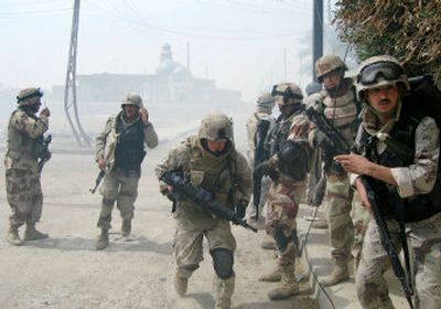 
U.S and Iraqi soldiers take cover during a street battle as gunfire echoes around them Saturday in Ramadi, west of Baghdad.
 (Associated Press / The Spokesman-Review)