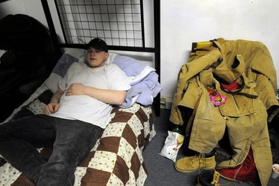 After working all day unloading semitrucks, Clayton Smith rests at Truth Ministries homeless shelter Tuesday night. The organization will hold a fundraiser Saturday, but what the all-volunteer shelter really needs are new regular donors to replace dropped support.  (Colin Mulvany / The Spokesman-Review)