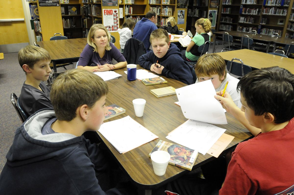 The Spokesman-Review Gabe George, Jake Borgford, parent Mary Schwedland, Alek Reiber, Greg Westover and Hayden Bash discuss the book “The Breadwinner” in the library at Bowdish Middle School  Dec. 12. Teacher Joshua Evans had his whole class read the book, about a young Afghan girl in the era of the Taliban. He then broke the students into groups, accompanied by a parent, to discuss the book. (Photos by JESSE TINSLEY / The Spokesman-Review)