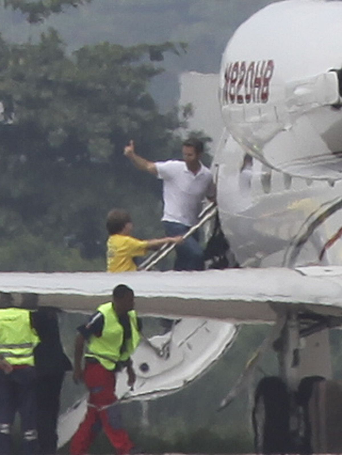 David Goldman and his son Sean   board a plane  in Rio de Janeiro, Brazil, Thursday.  (Associated Press)