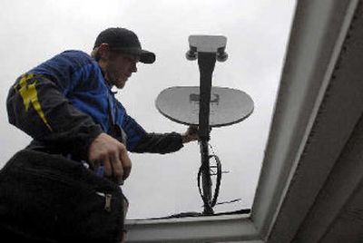 
Nick Corbin of All-American Satellite installs a satellite dish on a home in Coeur d'Alene Wednesday. Corbin and his company are getting orders for new dish receivers because the Spokane Fox network affiliate, KAYU, is in a dispute with Time Warner Cable, cutting off many North Idaho cable subscribers from football games and TV shows. 
 (Jesse Tinsley / The Spokesman-Review)