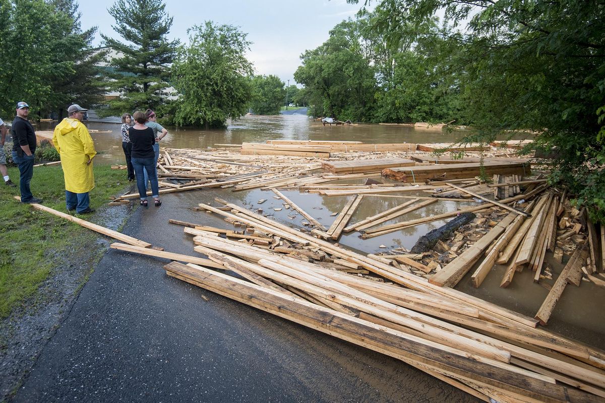 Floodwaters carrying lumber from Republic Trussworks on John Wayland Highway block Grace Chapel Road after a strong afternoon thunderstorm in Dayton, Va., Thursday, May 31, 2018. (Daniel Lin / AP)
