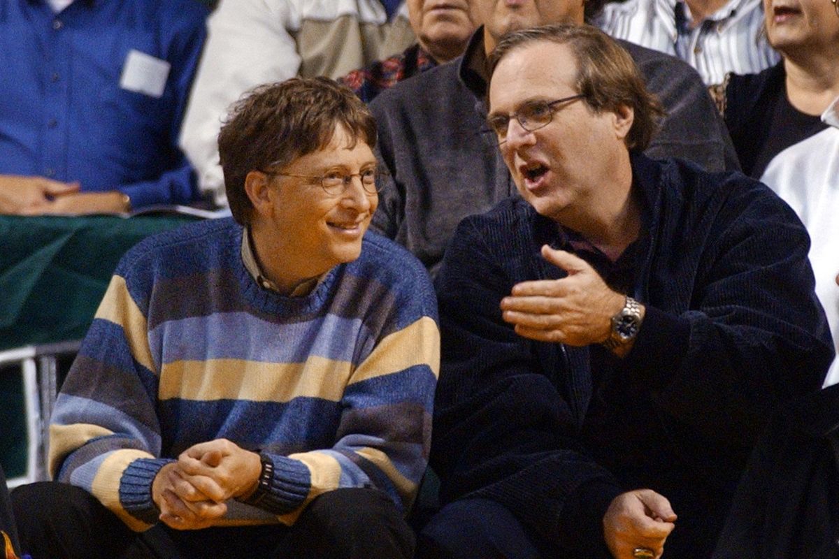 In this March 11, 2003 file photo, Microsoft Chairman Bill Gates, left, chats with Portland Trail Blazers owner and former business partner Paul Allen during a game between the Trail Blazers and Seattle SuperSonics in Seattle. Allen, billionaire owner of the Trail Blazers and the Seattle Seahawks and Microsoft co-founder, died Monday, Oct. 15, 2018 at age 65. Earlier this month Allen said the cancer he was treated for in 2009, non-Hodgkins lymphoma, had returned. (ELAINE THOMPSON / AP)