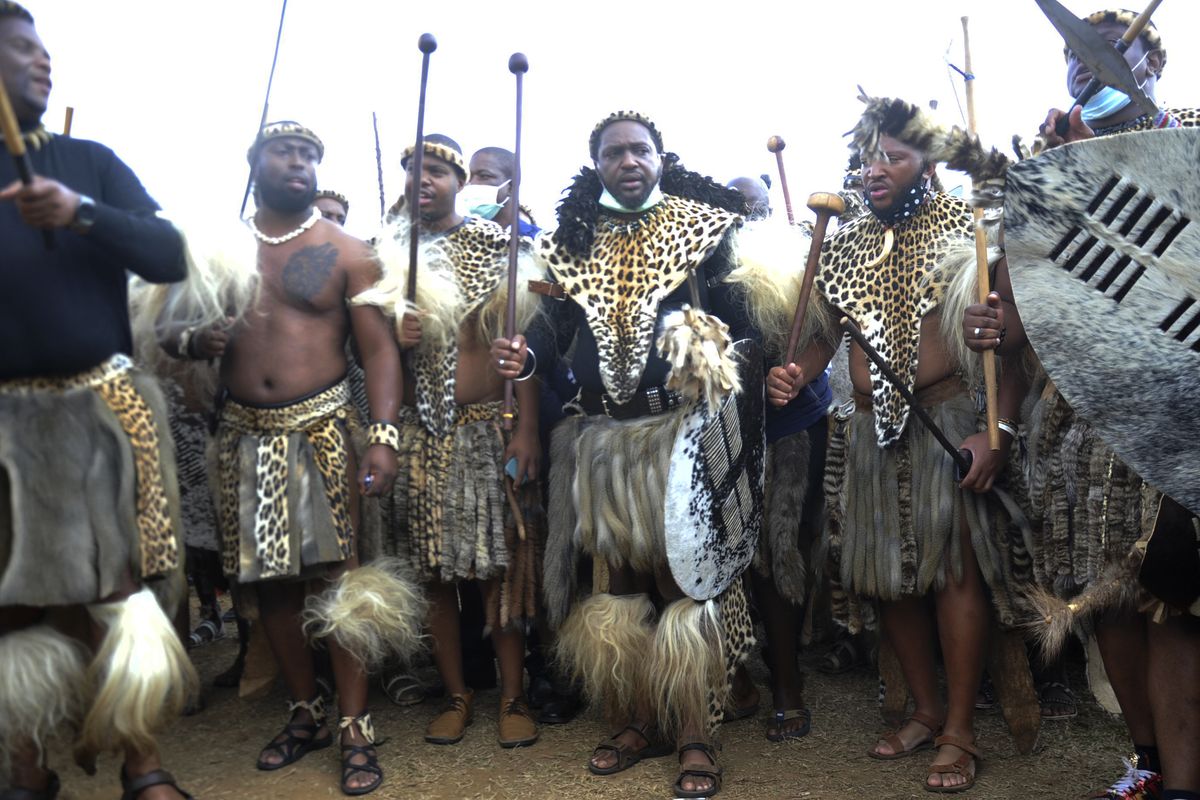Prince Misuzulu Zulu, center, flanked by fellow warriors in traditional dress at the KwaKhangelamankengane Royal Palace, during a ceremony, in Nongoma, Friday May 7, 2021. A new Zulu king in South Africa has been named amid scenes of chaos as other members of the royal family questioned Prince Misuzulu Zulu’s claim to the title. He was suddenly whisked away from the public announcement at a palace by bodyguards. The controversy over the next king has arisen after the death in March of King Goodwill Zwelithini, who had reigned since 1968. Zwelithini apparently named one of his six wives, Queen Mantfombi Shiyiwe Dlamini Zulu, as the “regent of the Zulu kingdom” in his will. But her death just over a week ago after holding the title for only a month has thrown the royal succession into turmoil.  (STR)