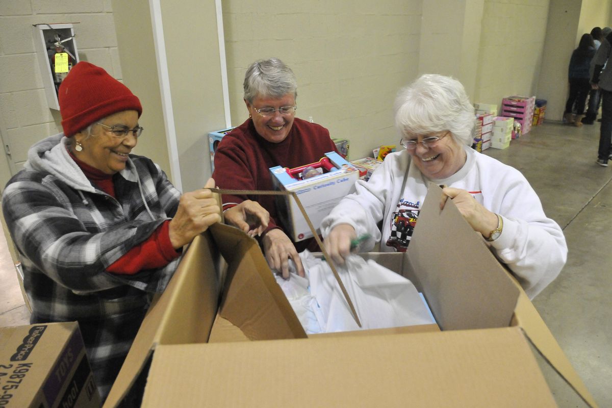 Volunteers, from left, Gwen Porche, Judy Hudson and Shirley Fifer unpack boxes of preschool toys Monday at the Spokane County Fair and Expo Center, the site of the annual Christmas Bureau. The bureau distributes toys and food vouchers to hundreds of families in need every Christmas season. (Jesse Tinsley)