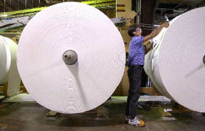 
A Potlatch worker tapes off giant rolls of paper in the mill in Lewiston.
 (File/ / The Spokesman-Review)