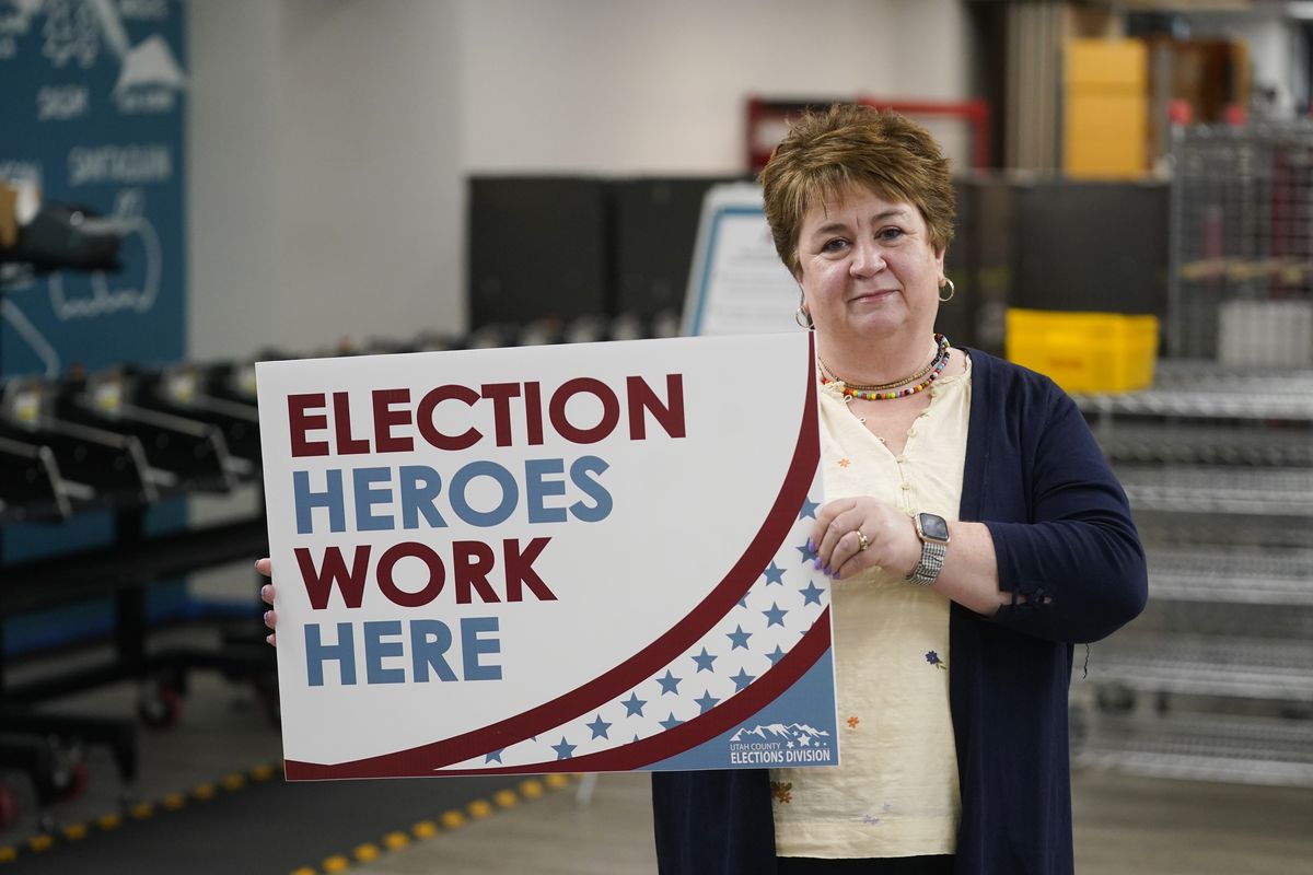 Utah County elections director Rozan Mitchell holds a "Election Heroes Work Here" sign during a tour of Utah County