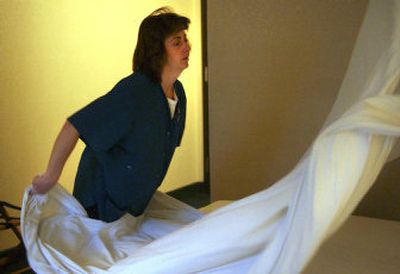 
Housekeeping supervisor and bed-making champion Becky Strange puts clean sheets on a bed in one of the rooms at the Argonne Super 8 Motel last week. 
 (Liz Kishimoto / The Spokesman-Review)