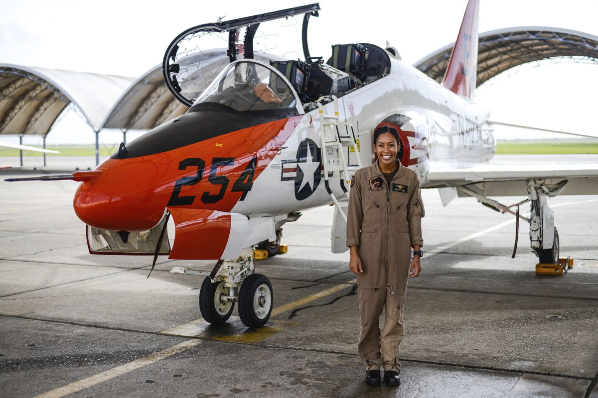 In this photo provided by the U.S. Navy, student Naval aviator Lt. j.g. Madeline Swegle, assigned to the Redhawks of Training Squadron (VT) 21 at Naval Air Station Kingsville, Texas, stands by a T-45C Goshawk training aircraft following her final flight to complete the undergraduate Tactical Air (Strike) pilot training syllabus, July 7, 2020, in Kingsville, Texas. Swegle is the Navy