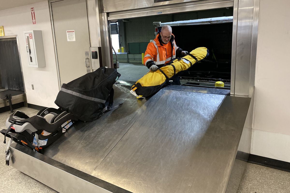 A baggage handler unloads oversized luggage at Spokane International Airport’s baggage claim in December.  (James Hanlon/The Spokesman-Review)
