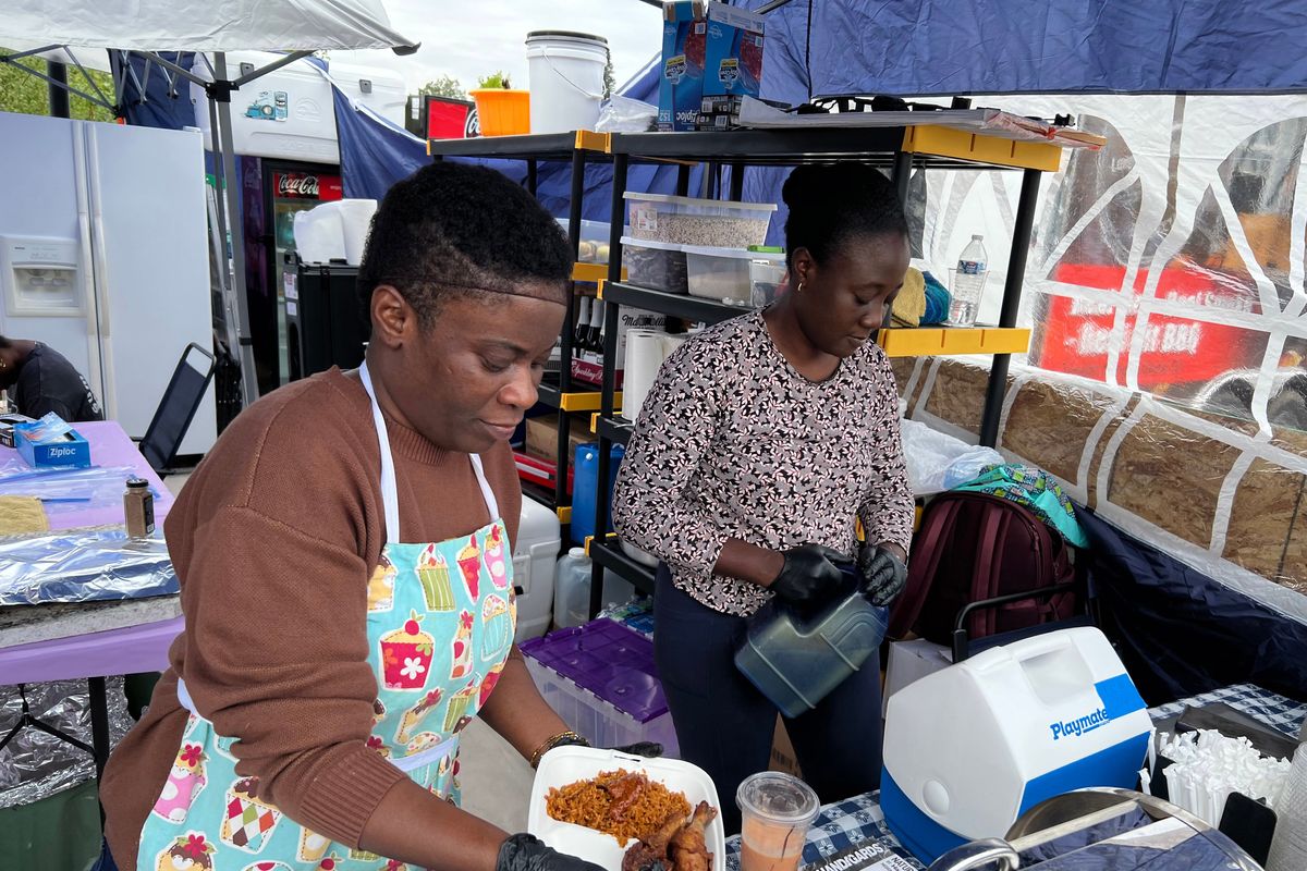Yvonne Frimpong, left, serves a jollof rice meal with chicken and coleslaw at Pig Out in the Park at Riverfront Park in Spokane on Thursday, Aug. 28, 2025. Frimpong and her sisters, Dorcas Awuah, right, and Perpetual Barnes, own African Cuisine Spokane, which is making its second appearance at Pig Out this year. (Jonathan Brunt/The Spokesman-Review)