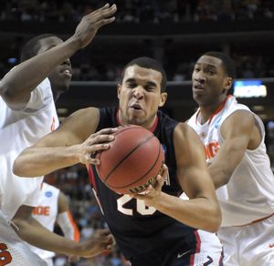 Gonzaga’s Elias Harris is hit from both sides by Syracuse players as he fights for an offensive rebound.