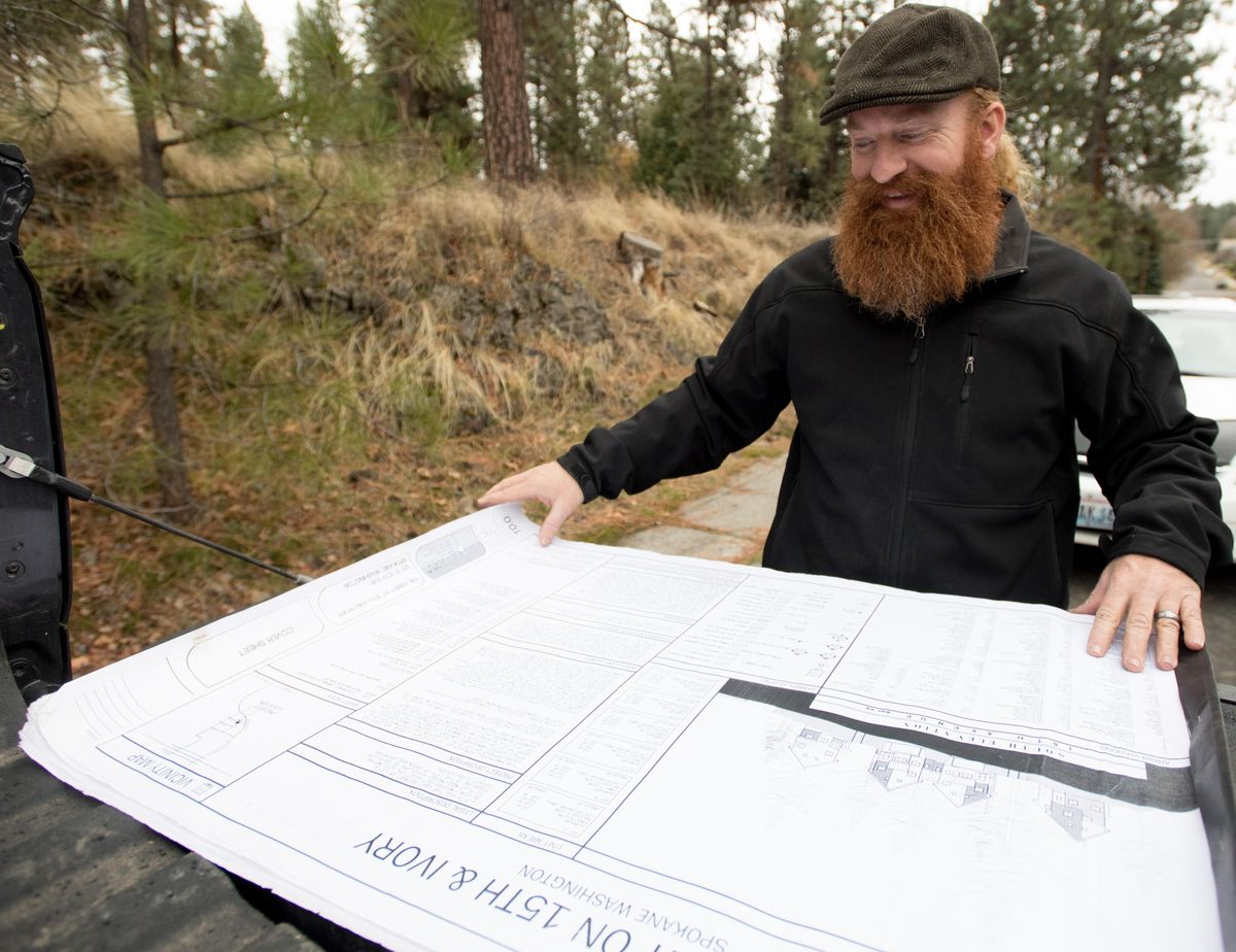 Developer Grant Keller smiles as he shows the plans for cottage homes he plans to build at 15th Avenue and Ivory Street in the South Perry District on Wednesday, Nov. 15, 2017, in Spokane. Laws passed by the City Council on Monday night are intended to make developments like the one Keller proposes more attractive to builders and promote more affordable housing within city limits. (Tyler Tjomsland / The Spokesman-Review)