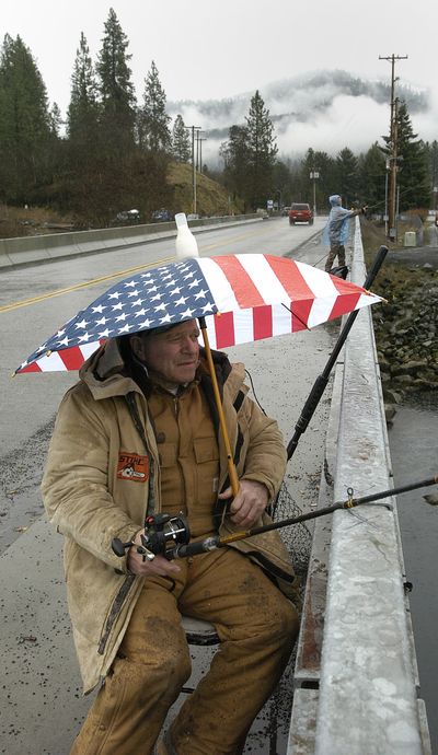 ORG XMIT: IDLEW101 Bill Bowen of Whitehall, Mont., keeps dry with a little help from an umbrella as he fishes for steelhead Thursday, March 5, 2009 near Orofino, Idaho. (AP Photo/Lewiston Tribune, Kyle Mills) (Kyle Mills / The Spokesman-Review)
