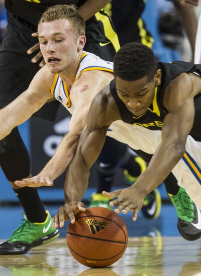 UCLA guard Nick Kazemi, left, and Oregon guard Dominic Arts, right, battle for a loose ball in the first half. (Associated Press)