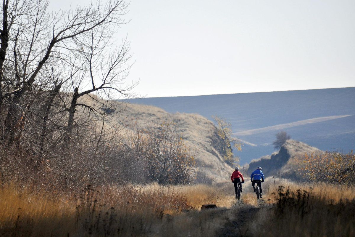 Chip Andrus, left, and Pat Sprute of Spokane cycle on the abandoned railway called the John Wayne Trail near Rosalia. (Rich Landers / The Spokesman-Review)