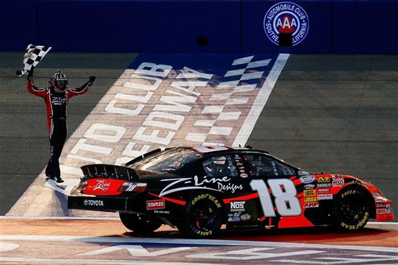 Kyle Busch, driver of the No. 18 Z-Line Designs Toyota, celebrates on the track with the checkered flag and the fans after winning the NASCAR Nationwide Series Stater Bros. 300 at Auto Club Speedway. (Photo courtesy Jason Smith/Getty Images for NASCAR)