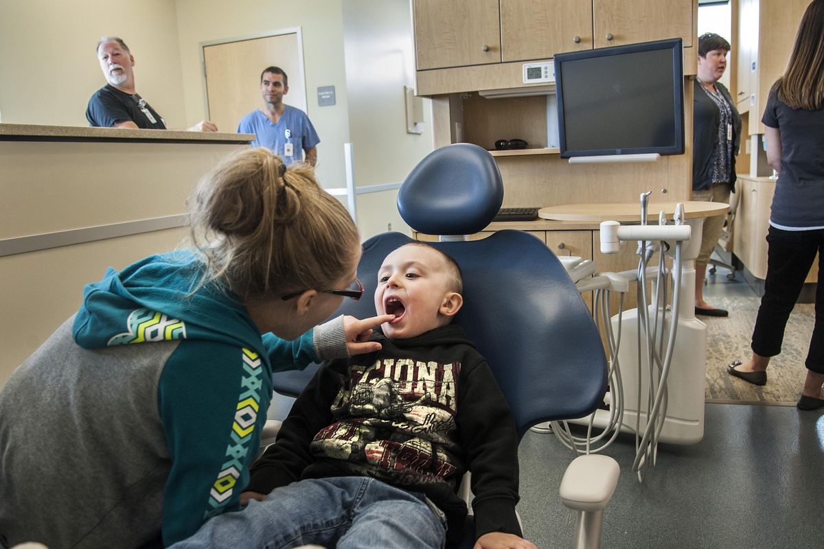 Rylan Talmage, 3, gets a dental exam in the dental clinic from his sister, Amarah, 10, during a tour Tuesday of the new CHAS Cheney Health Center. Dentist Bill Pedey is second from left in the rear. The children’s father, Glenn, works for CHAS. (Dan Pelle / The Spokesman-Review)