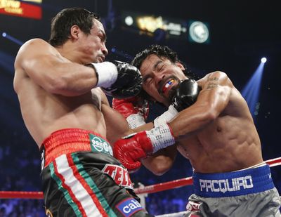 Juan Manuel Marquez, left, and Manny Pacquiao trade blows. (Associated Press)