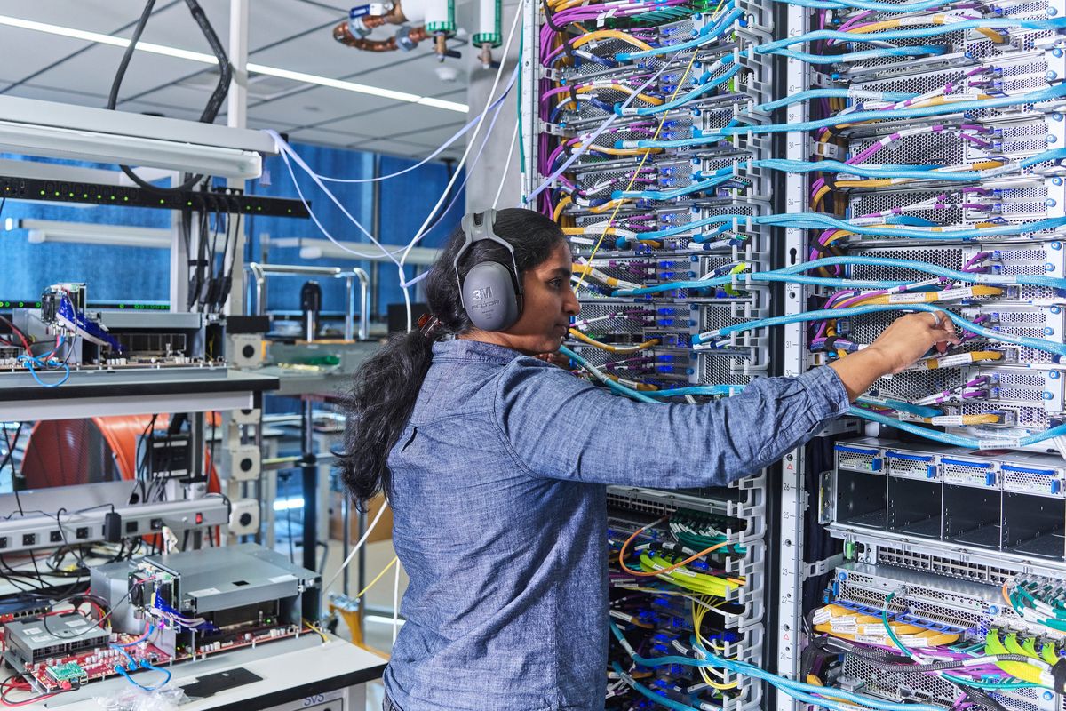 An employee works with a Trainium 2 system at an Amazon facility on Nov. 25 in Austin, Texas. Amazon, Advanced Micro Devices and several start-ups are beginning to offer credible alternatives to Nvidia’s market-dominating chips.  (New York Times)