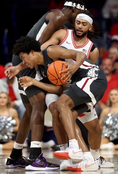 Washington State forward Jaylen Wells (0) uses a screen from center Rueben Chinyelu (20) to escape the defense of Arizona guard Kylan Boswell (4) in the first half of their Pac-12 game in Tucson.  (Kelly Presnell/Arizona Daily Star)