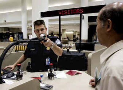 
Joshua Akronowitz, a U.S. Customs and Border Protection officer, photographs a traveler Thursday from Japan at Los Angeles International Aiport .
 (Associated Press / The Spokesman-Review)