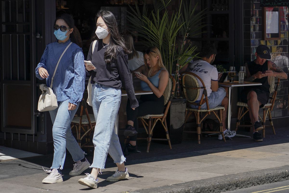 People sit at outdoor tables at a restaurant in Soho, in London, Monday, June 14, 2021. British Prime Minister Boris Johnson is expected to confirm Monday that the next planned relaxation of coronavirus restrictions in England will be delayed as a result of the spread of the delta variant first identified in India.  (Alberto Pezzali)