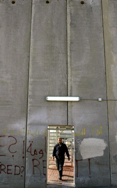 
A Palestinian man crosses from Jerusalem through a door in a section of Israel's separation barrier in the West Bank town of Bethlehem in this May 10 photo. 
 (Associated Press / The Spokesman-Review)