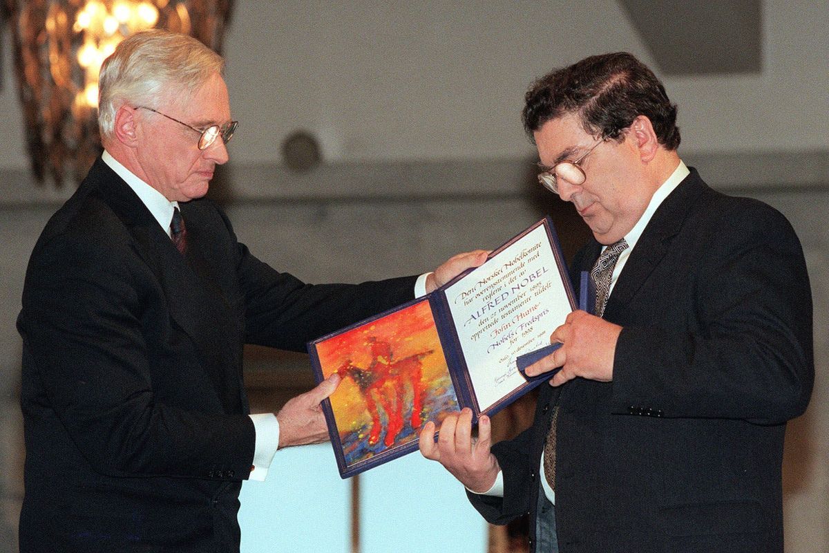 FILE - In this Dec. 10, 1998 file photo, John Hume, right, looks at the Nobel Peace Prize diploma which he received from Francis Sejersted, left, chairman of the Norwegian Nobel Peace Prize Committee during the award ceremony in Oslo Town Hall. The family of politician John Hume, who won Nobel Peace Prize for work to end violence in Northern Ireland, says he has died. He was 83. The Catholic leader of the moderate Social Democratic and Labour Party , Hume was regarded by many as the principal architect behind the peace agreement.  (BJOERN SIGURDSOEN)