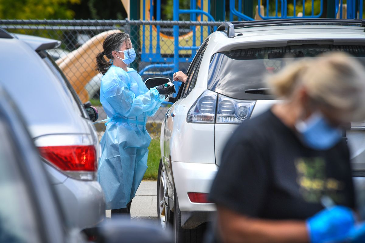 Spokane Regional Health District and volunteer nurses conduct curbside COVID-19 testing in the parking lot at Holmes Elementary School in July.  (DAN PELLE/THE SPOKESMAN-REVIEW)