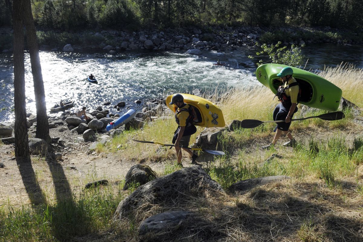 Kayakers walk down the trail to a put-in on the upper Spokane River. Paddlers are surrounded by hundreds of lakes and streams within four hours of the city. (FILE)