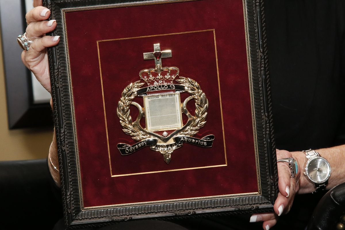 In this Tuesday, April 18, 2017, photo, Carol Mersch holds a copy of a microfilm Bible that flew in orbit around the moon on Apollo 14 during an interview in her home in Tulsa, Okla. Ten microfilm Bibles once launched hundreds of thousands of miles into space are today landlocked inside an Oklahoma court vault while a legal battle rages in two states over their rightful owner. (Sue Ogrocki / Associated Press)