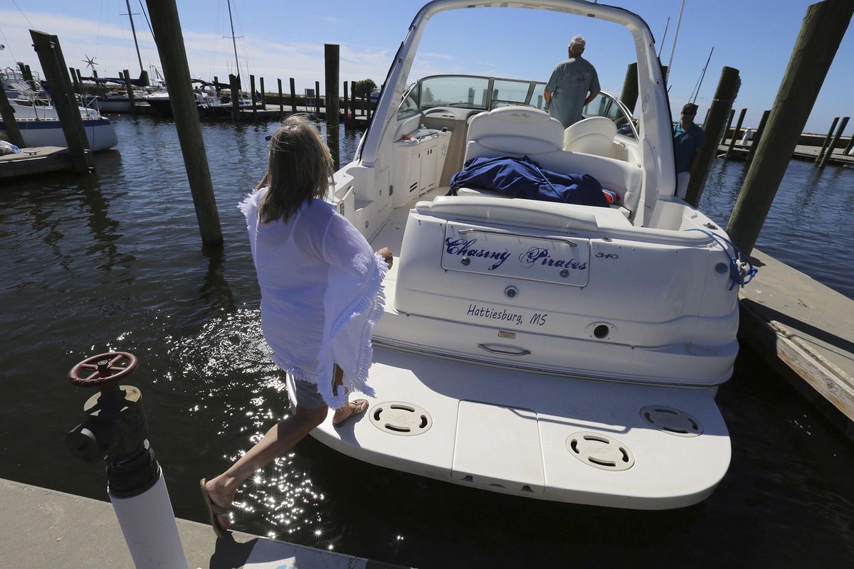 Brenda Kent jumps on her boat as she and her husband leave the Biloxi Small Craft Harbor in Biloxi, Miss., on Friday, Oct. 6, 2017 to take the boat up river in advance of Tropical Storm Nate. (John Fitzhugh / Associated Press)